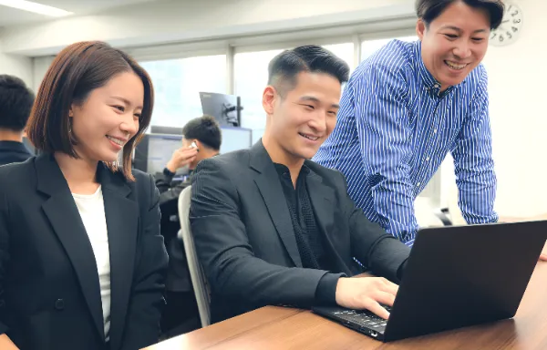 PC見ながら会話する社員3人